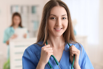 Female medical assistant with stethoscope in clinic, closeup