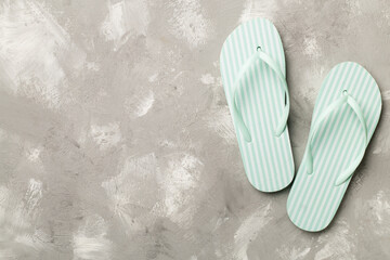 Striped flip flops on concrete background, top view