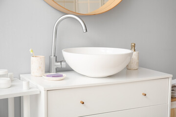 Fototapeta na wymiar Ceramic sink and bath accessories on drawers in bathroom