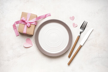 Table setting for Valentine's Day with hearts and gift on grey table
