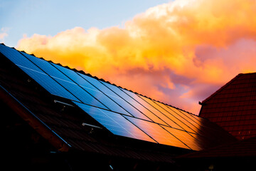 the sunset paints the sky red, reflecting off the shiny solar panels - 567546899