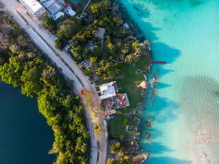 Aerial Top View on narrow line of land between Cenote Azul and 7 seven colors lagoon in Bacalar, Quintana Roo, Mexico - obrazy, fototapety, plakaty