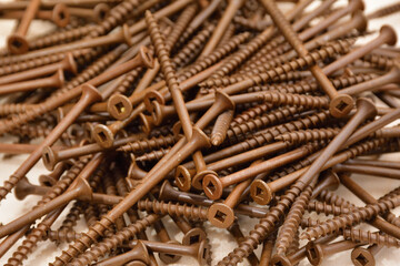 Ceramic coated brown flat head wood screws. Square head outdoor screws. Robertson deck screws. Pile of coarse thread wood screws.