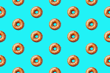 Colorful blue background with symmetrical donuts as a border, flat lay top down view. Food concept