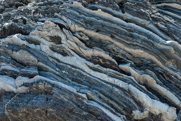 Compressed rock layers formation in various colors and thicknesses, on south central coast of the Mediterranean island Crete, Greece. Nature and Geological science concept