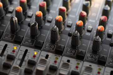 Audio mixing console in a streaming, live broadcast, or recording session. Channel faders close up....
