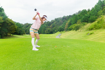ゴルフをする若い女性