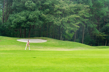 ゴルフをする若い女性