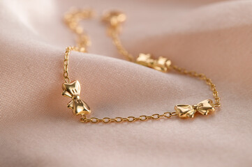 Gold children's bracelet on pink background. Advertising still life product,