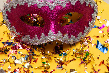 colorful carnival mask on the yellow background with several ornaments