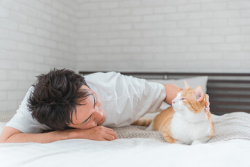 家のベッドルーム・寝室でくつろぐ猫と飼い主の男性（リラックス）
