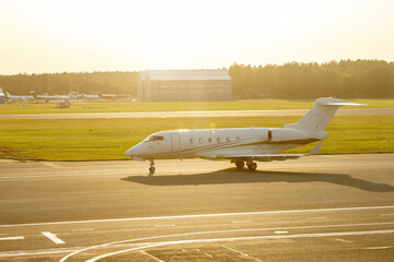 A small luxury private business jet on the airport runway strip.