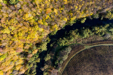 View from a great height on the bend of the river surrounded by autumn forest. The Nara River in the Kaluga region near the village of Papino, Russia