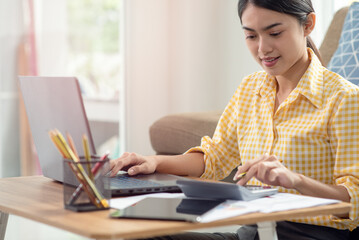 Young Asian businesswoman working with laptop at her house, work from home, business concept