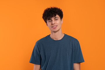 Fototapeta premium Portrait of handsome young man on orange background