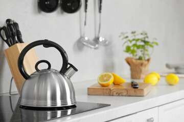 Stylish kettle with whistle on cooktop in kitchen. Space for text
