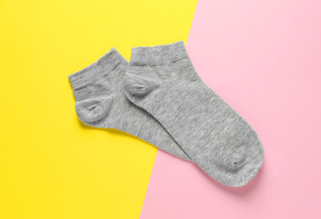 Pair of grey socks on colorful background, flat lay