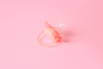 One new baby pacifier on pink background