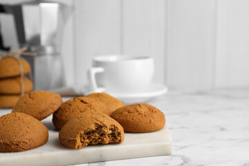 Tasty oatmeal cookies on white marble table. Space for text