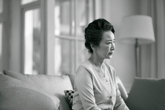 black and white portrait of a sad asian elderly woman