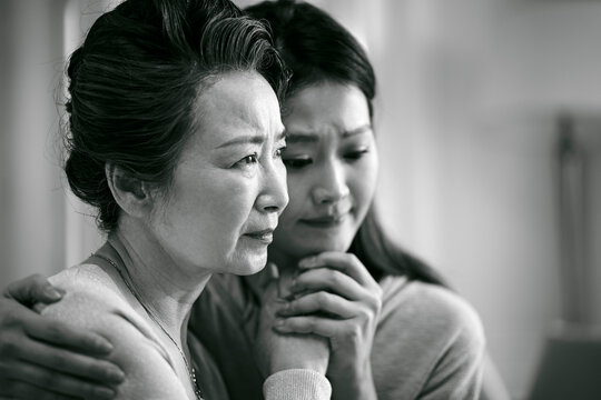 grieve asian senior mother and adult daughter
