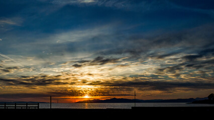 Winter sunset across the San Francisco Bay with orange, yellow blue sky. 