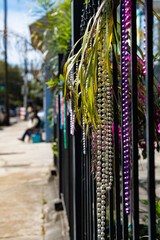 Colorful Mardi Gras beads hanging on iron fencing background