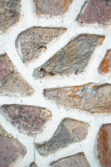 Imagen vertical de un mamposteo de piedras con un camino blanco de cemento pared vieja desgastada ideal para portadas 