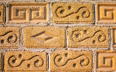 Imagen de una pared de ladrillos amarillos con figuras portada con textura urbana