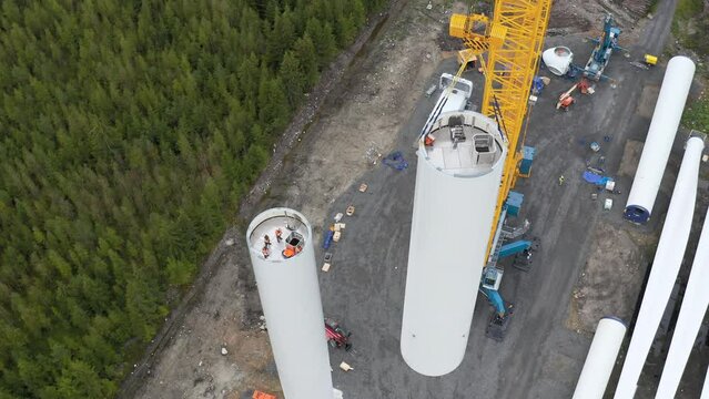 Hoisting process of a part of the tower of a wind turbine power generator, high angle view