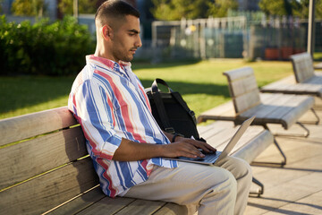 Handsome middle eastern programmer using laptop computer working freelance project online at...