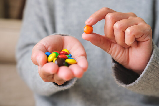Closeup image of hands holding and showing colorful chocolate candy
