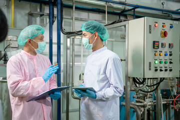 Obraz premium A quality supervisor or food or pharmaceutical technician discuss about process control of food and drugs before send product to the customer. Production leader recheck parameter and productivity.