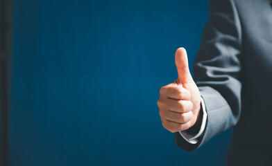 Close up of businesswoman showing raised thumbs at the camera as a gesture of recommendation or good choice. Professional support and service team demonstrates satisfaction and gives a positive.