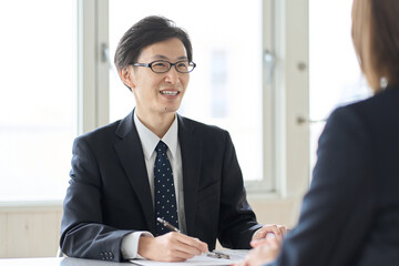 税金の相談を受けるアジア人男性税理士