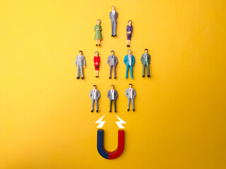 Businessman attracts by magnet on a yellow background. Business and leadership concept.