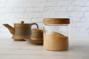 coconut sugar in jar and a tea cup on table 