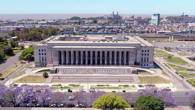 Aerial view dolly in front of the UBA Law School on a sunny day with the power plant of the Port of Buenos Aires, Argentina. Cathedral of Electricity