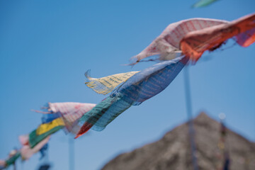 Lungta Prayer flags on blur blue background. A Tibetan prayer flag is a colorful rectangular cloth,...