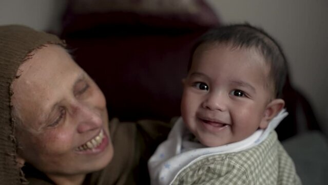 Bangladeshi Grandmother And Grandson Smiling AtsThey Loving Look At Each Other. Slow Motion