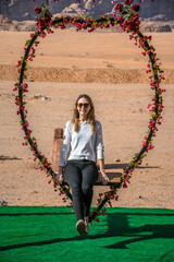kobieta na huśtawce w kształcie serca na pustyni