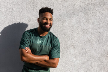 Happy Black male athlete smiling arms crossed after outdoor workout