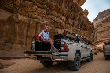 kobieta siedząca na pace samochodu terenowego na pustyni