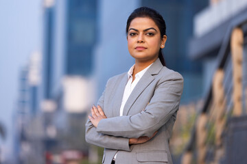 Young woman in business wear standing with armes crossed in business environment,