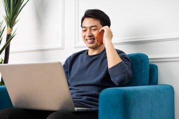 portrait of asian man sitting on sofa at home 