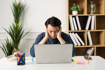 image of Asian man sitting at home working