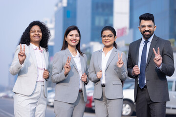 Group of successful business people showing victory sing.