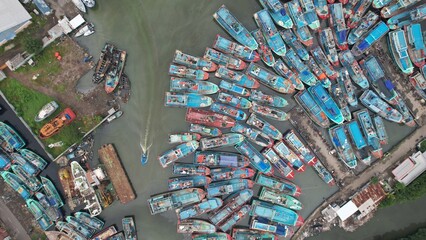 Aerial view of a fishing port with several fishing boats parked in a very chaotic manner