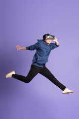 Fototapeta na wymiar image of asian man wearing virtual reality glasses on purple background
