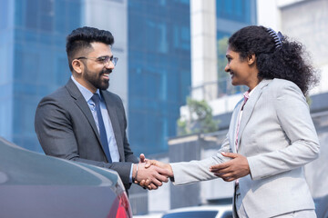Business people shaking hands outside office building